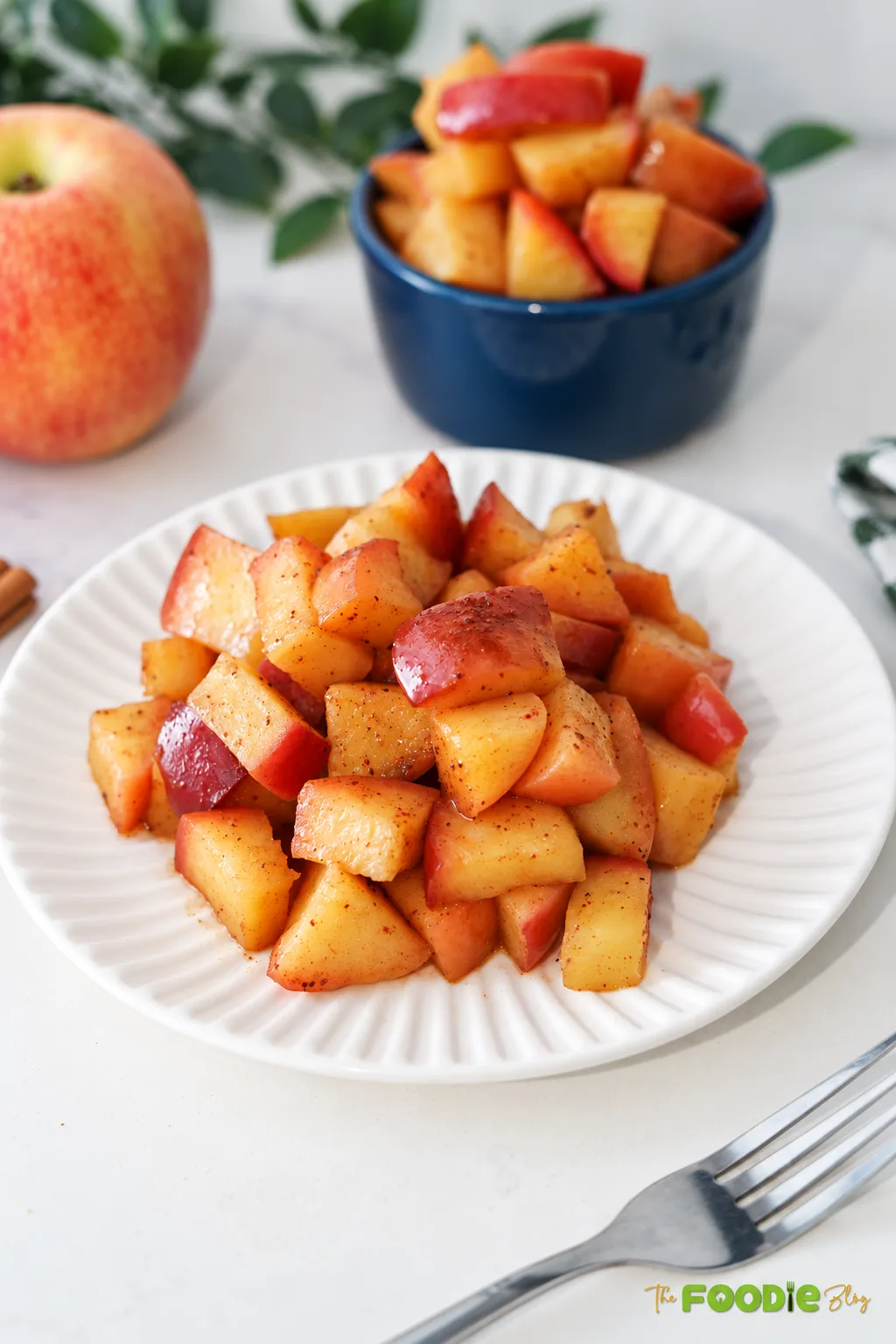 Stovetop cinnamon apples with maple syrup served on a white plate
