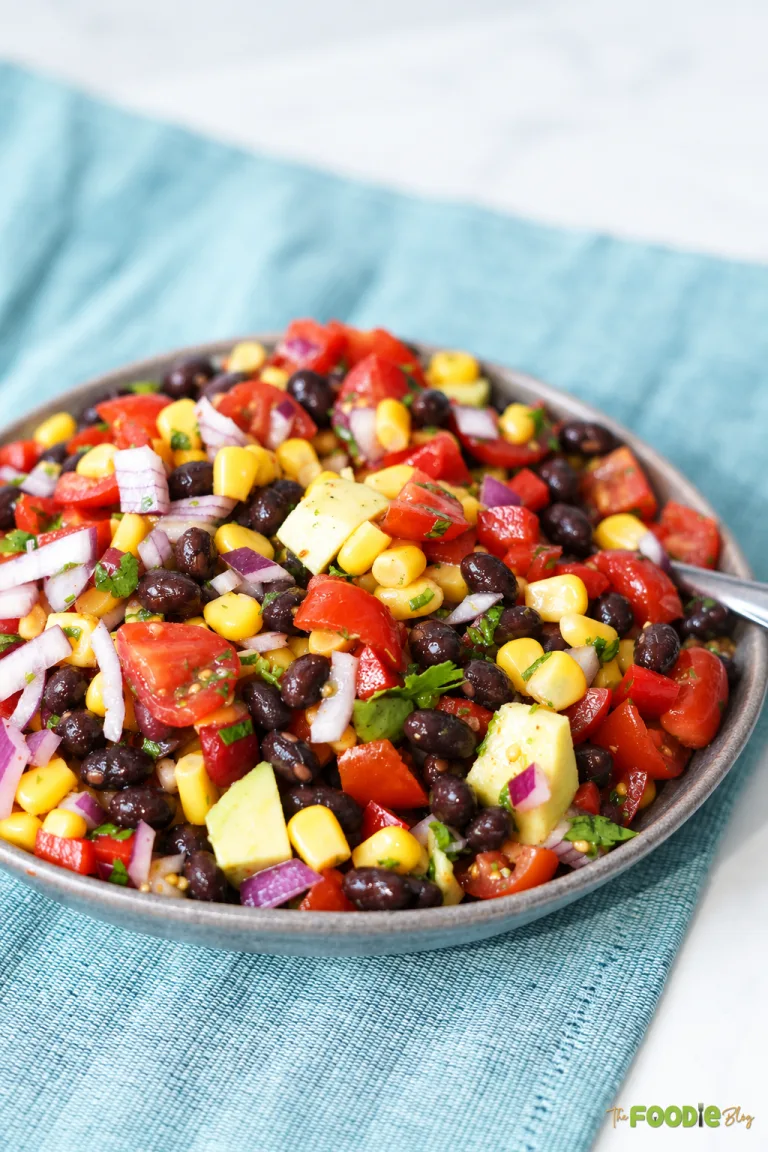 Cowboy caviar with black beans, corn, avocado, cherry tomatoes, red onion, and cilantro.