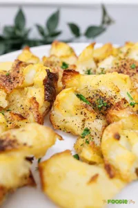 Crispy smashed potatoes with golden brown edges, black pepper, and fresh parsley.
