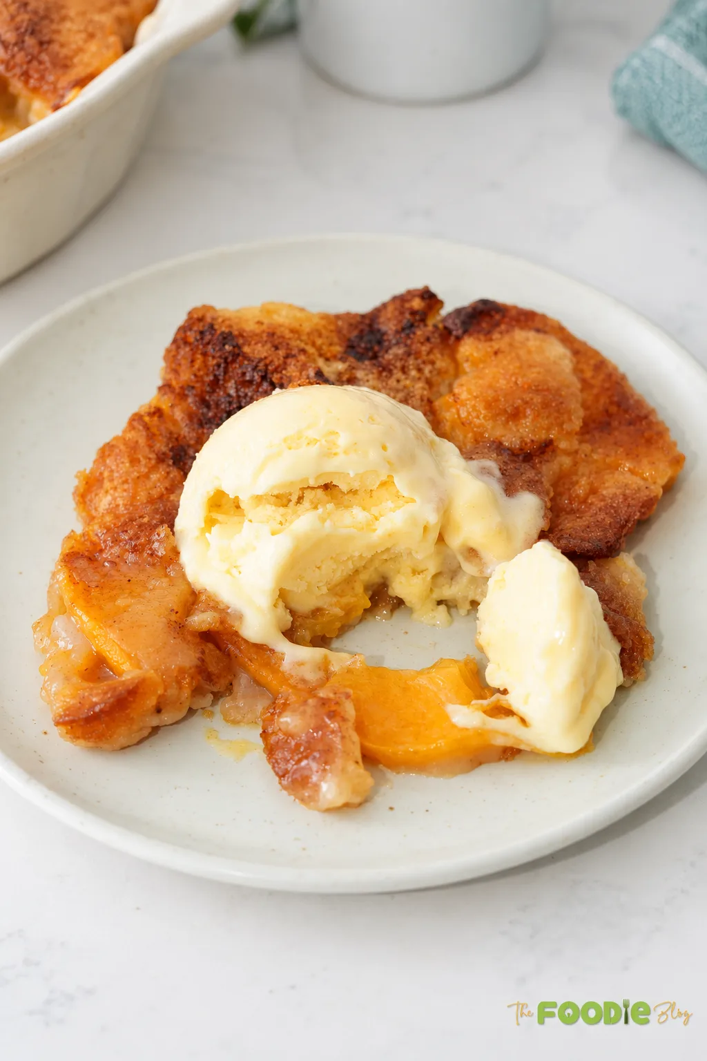 Easy canned peach cobbler served warm with a scoop of vanilla ice cream.