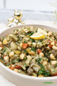 Close-up of eggplant chickpea salad with roasted peppers, parsley, and lemon.
