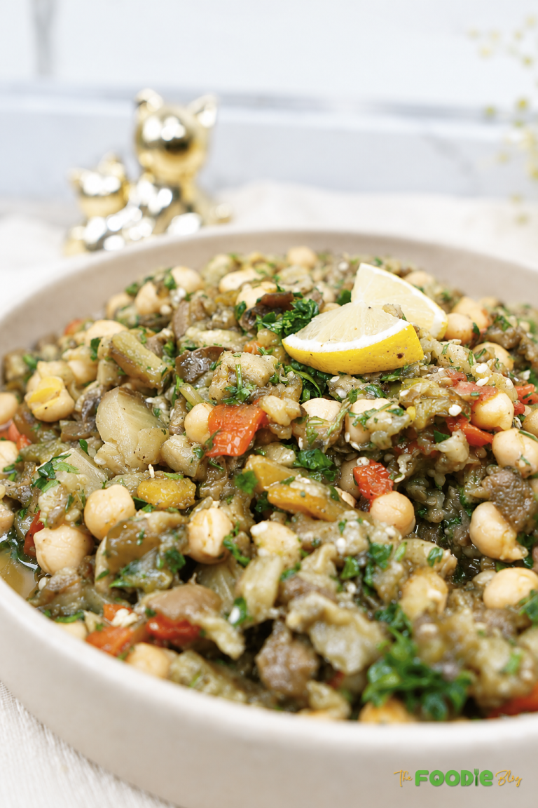 Close-up of eggplant chickpea salad with roasted peppers, parsley, and lemon.