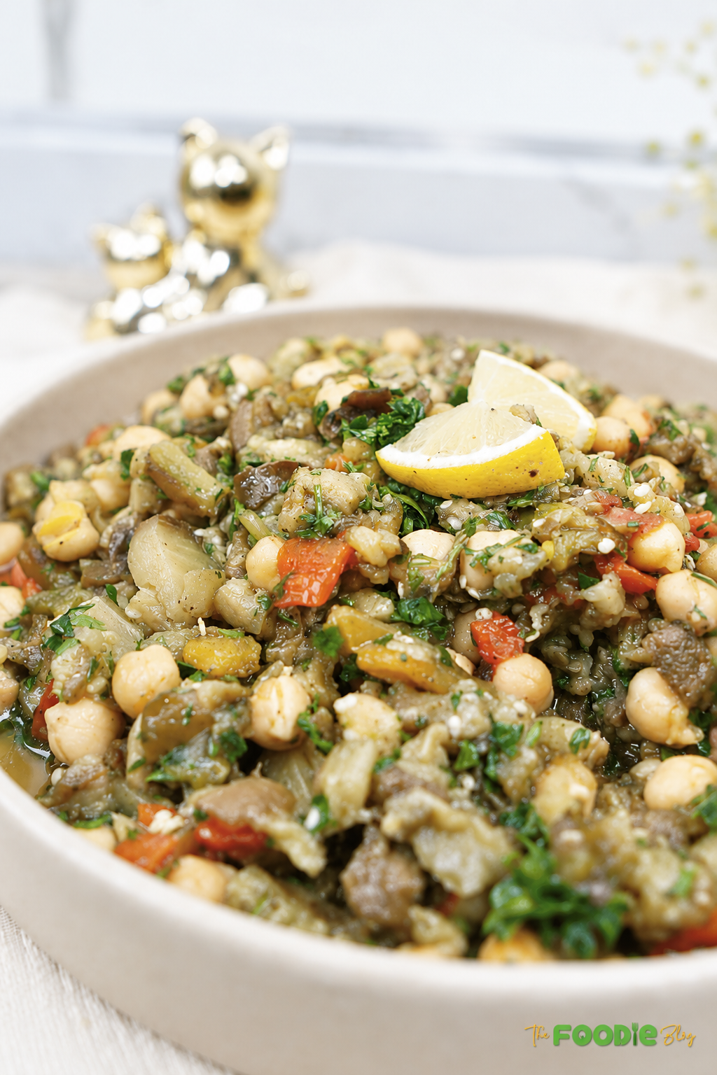 Close-up of eggplant chickpea salad with roasted peppers, parsley, and lemon.
