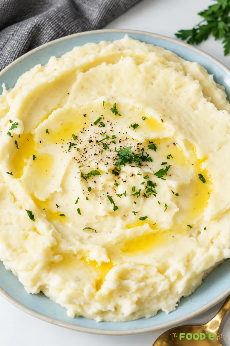 Easy mashed potatoes topped with melted butter, black pepper, and fresh parsley.