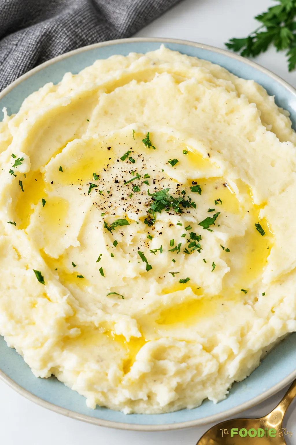 Easy mashed potatoes topped with melted butter, black pepper, and fresh parsley.