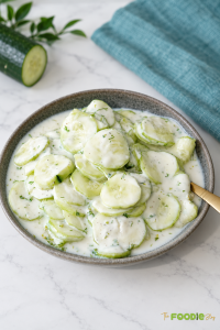 Creamy German cucumber salad with sliced cucumbers, sour cream dressing, fresh dill, and black pepper.