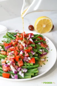 Green bean and tomato salad with red onion, parsley, and lemon Dijon dressing.