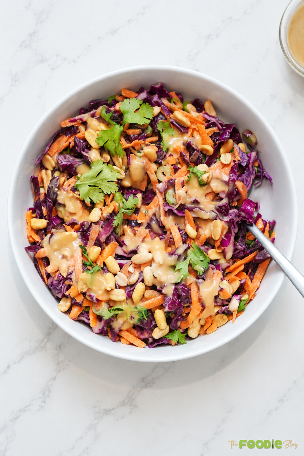 Close-up of crunchy Asian slaw with purple cabbage, carrots, peanuts, and cilantro.