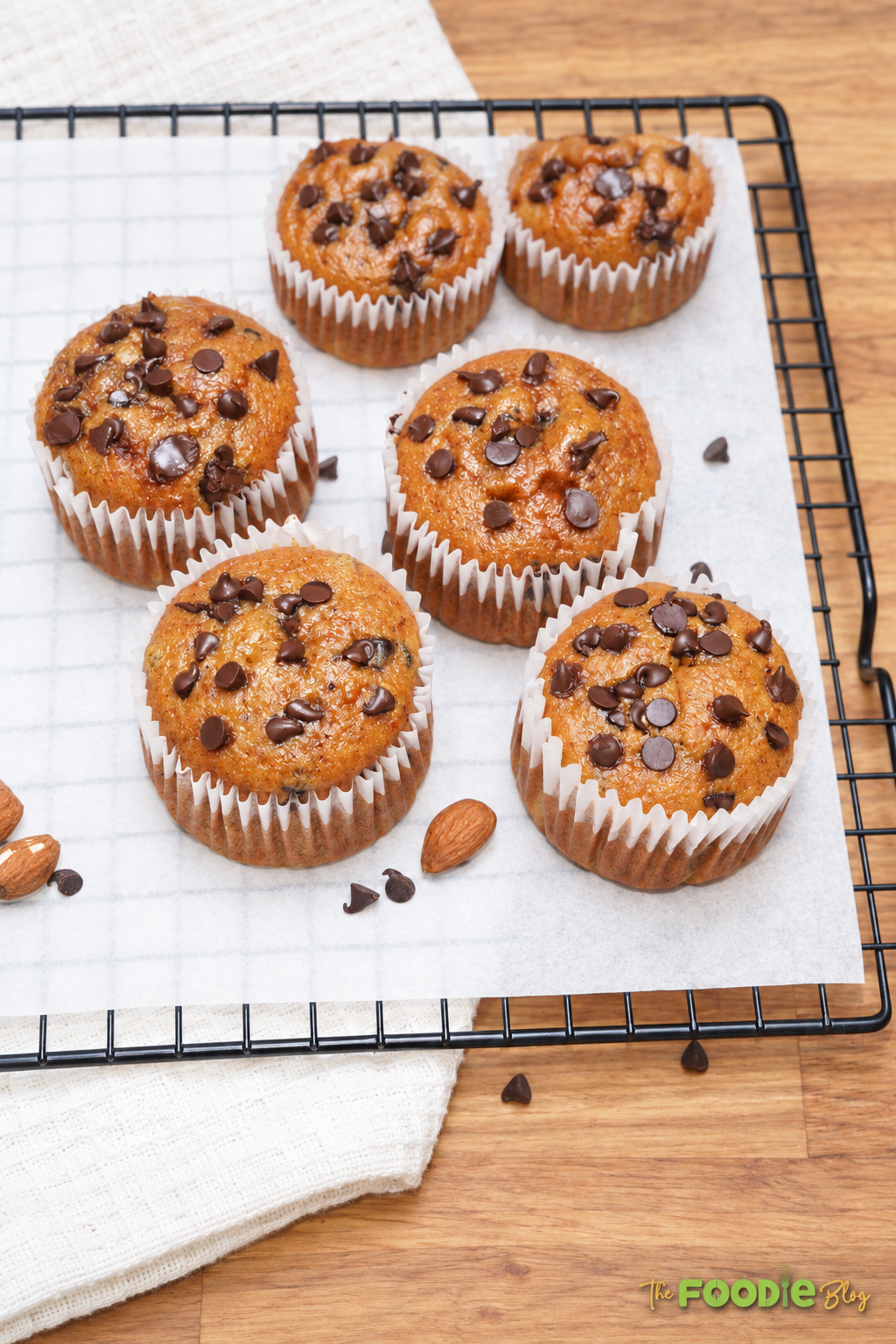 Freshly baked banana protein muffins with chocolate chips cooling on a wire rack.