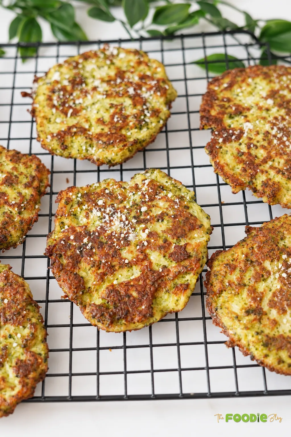 Close-up of golden broccoli fritters with crispy edges and Parmesan.