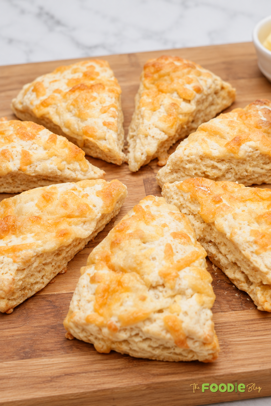 Homemade cheddar cheese scones arranged on a wooden board.