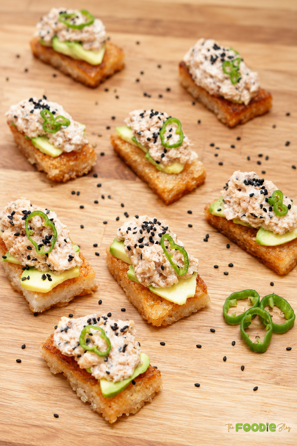 Platter of crispy rice bites topped with avocado, spicy tuna, jalapeño, and black sesame seeds.