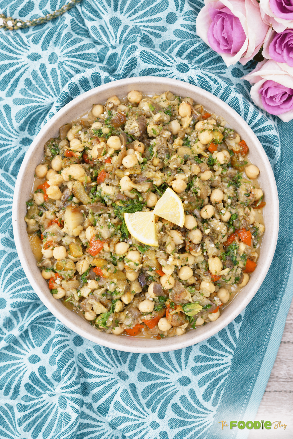 Easy eggplant chickpea salad served in a bowl with roasted vegetables, parsley, and lemon.
