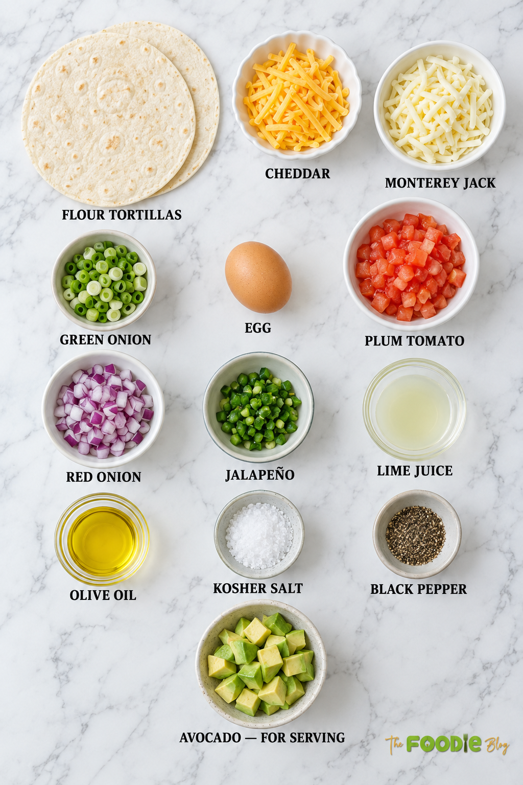 Ingredients for egg quesadilla including flour tortillas, cheddar, Monterey Jack, egg, tomato, onion, jalapeño, lime, and avocado.