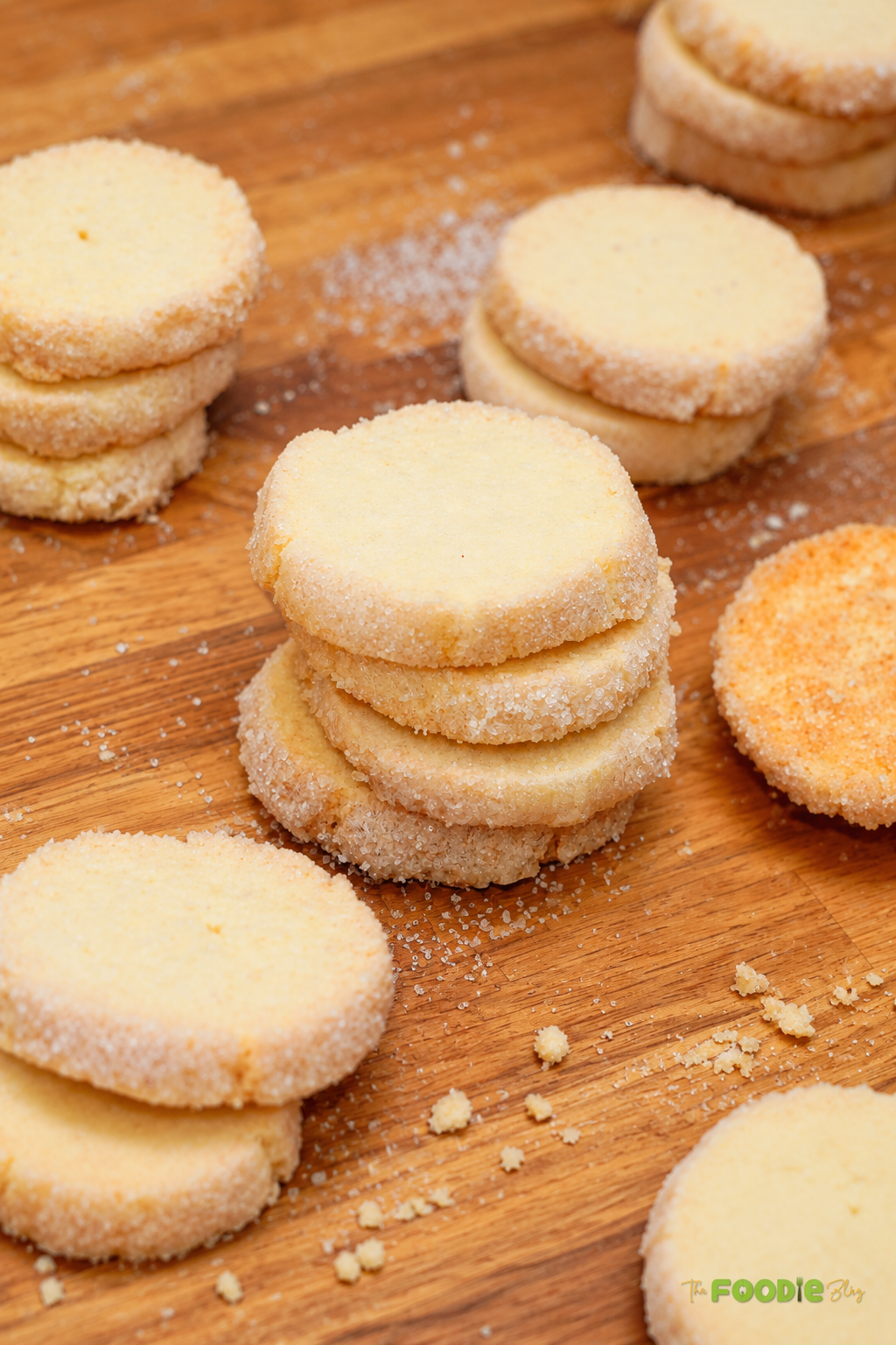 Stacks of homemade French sablé cookies with sparkling sugar around the edges.