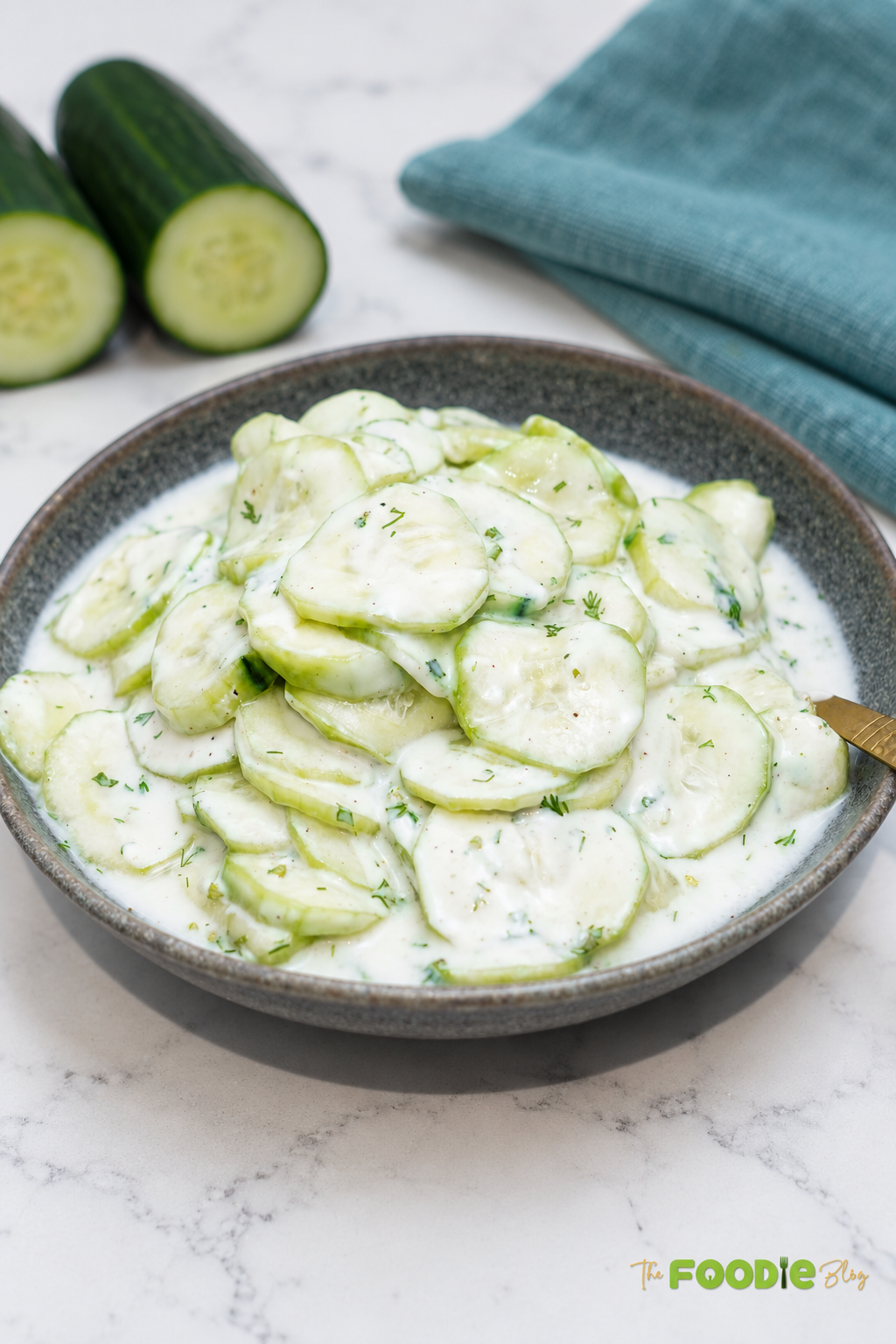 German cucumber salad served in a bowl with creamy dill dressing and fresh cucumber slices.