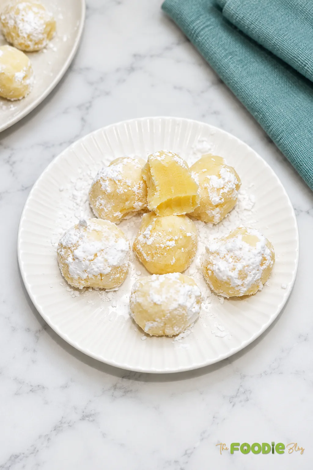 Easy lemon truffles dusted with powdered sugar on a white plate