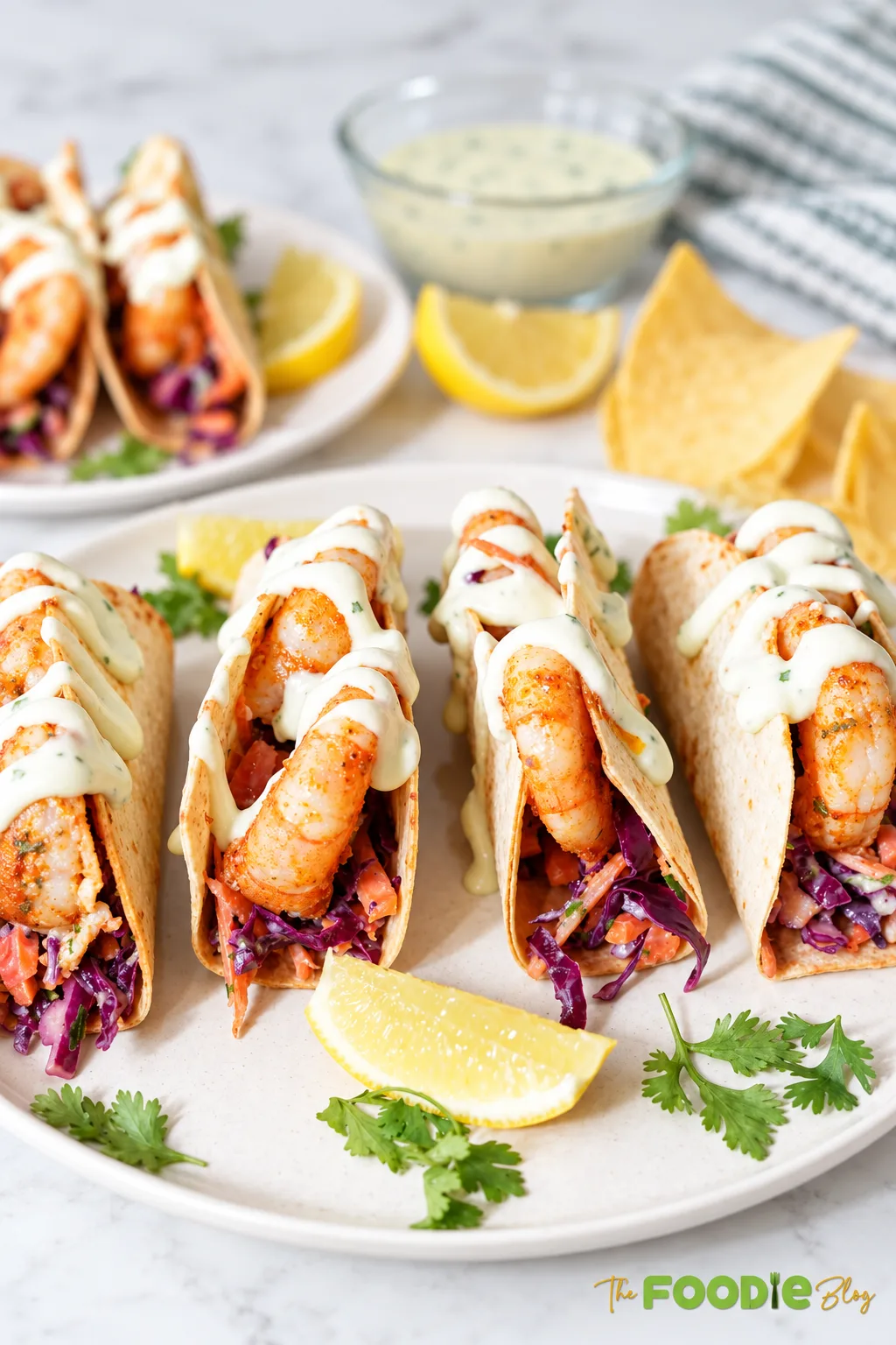Shrimp tacos filled with crunchy cabbage slaw and topped with creamy cilantro lime avocado crema.