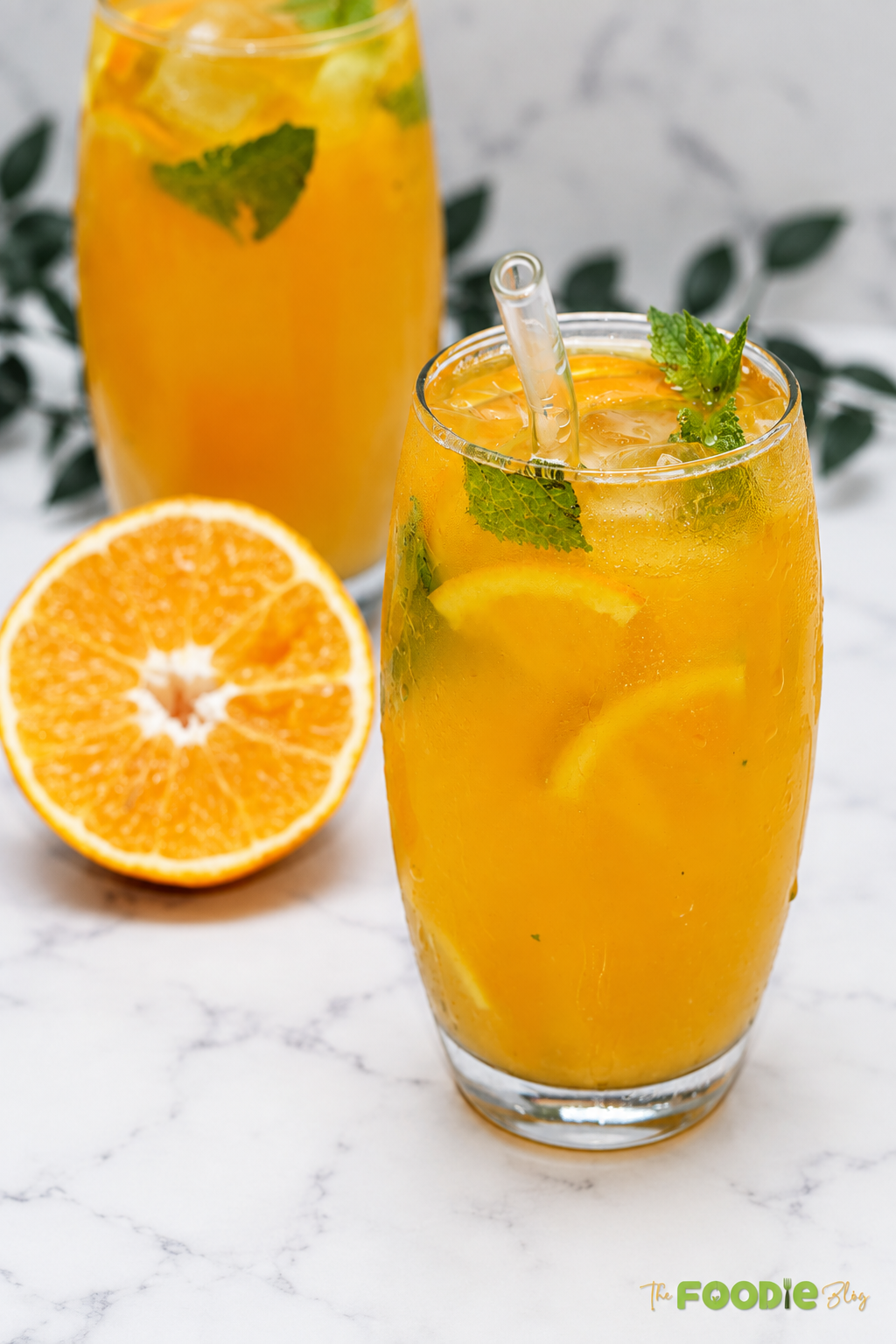 Chilled orange mojito served over ice with fresh mint and orange slices.