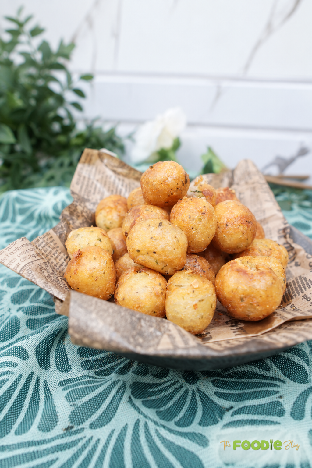 Bowl of crispy golden potato balls seasoned with herbs and served as an easy appetizer or snack.