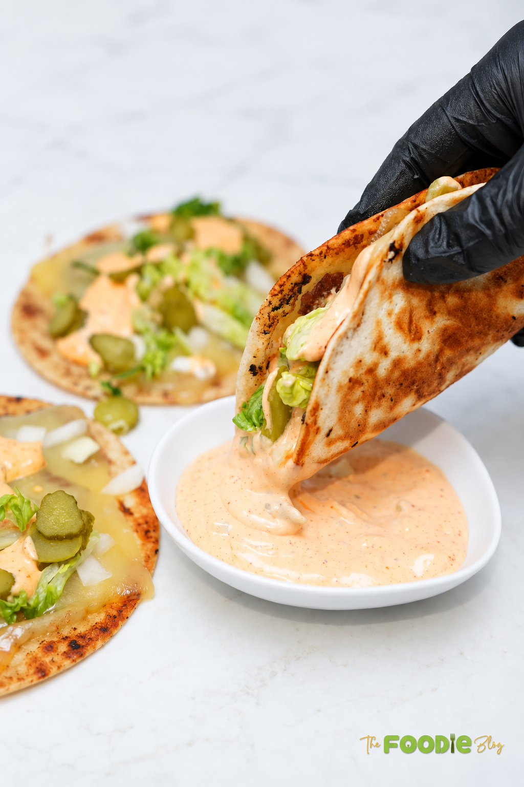 Close-up view of an easy smash burger taco with crispy tortilla, juicy beef, melted cheese, crunchy lettuce, pickles, onions, and burger sauce.