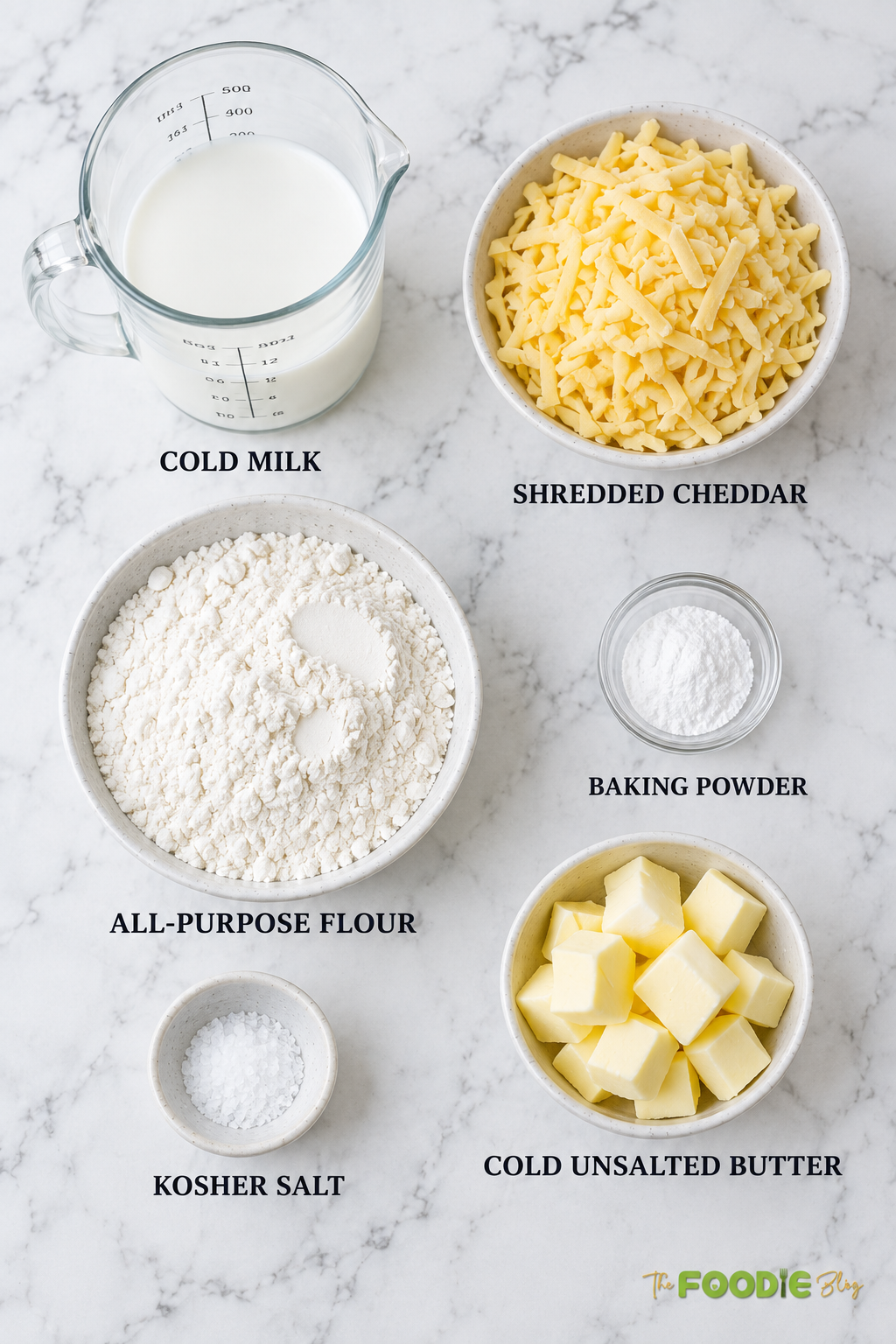 Cheddar scones ingredients including flour, cheddar cheese, milk, butter, baking powder, and salt.