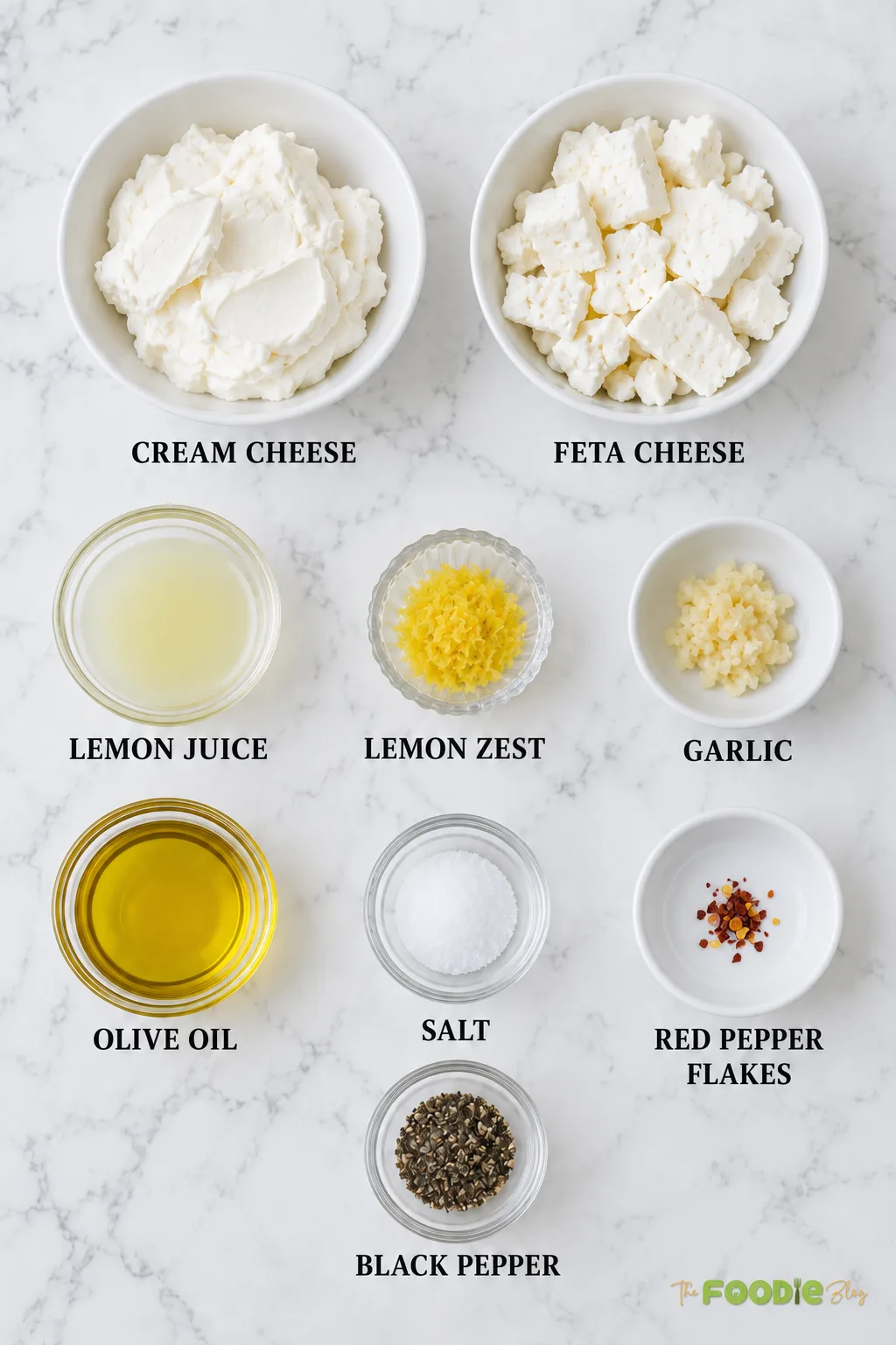 Ingredients for feta cream cheese dip including cream cheese, feta, lemon, garlic, olive oil, and seasonings.