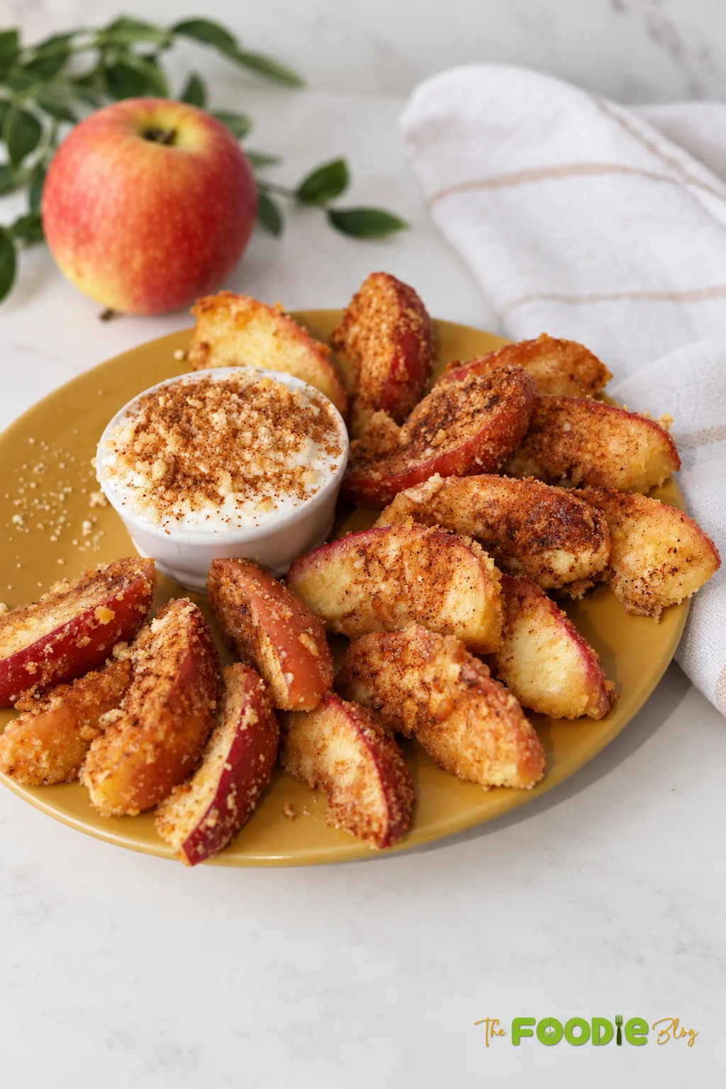 Cinnamon air fryer apple fries served on a plate with creamy dipping sauce.