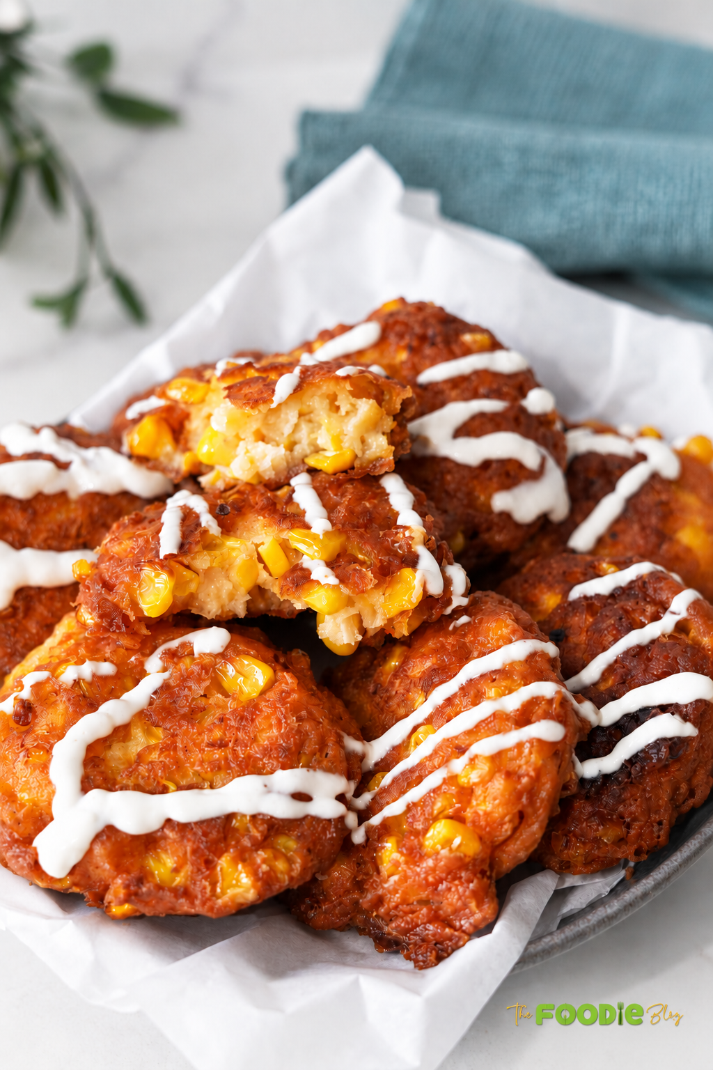 Crispy corn fritters broken open to show a soft center filled with sweet corn and feta cheese.