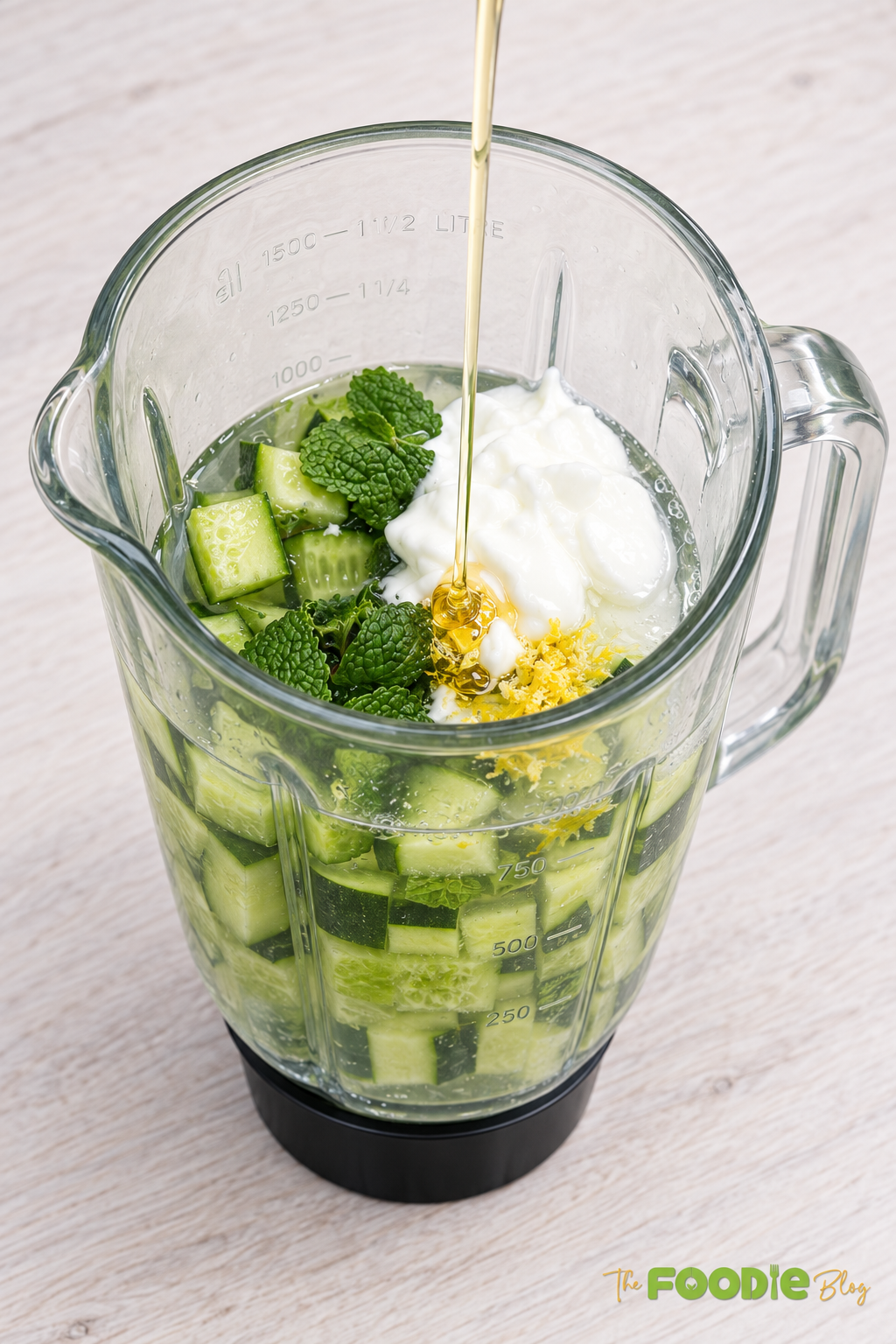 Chopped cucumber and fresh mint leaves in a blender with water and lemon juice.