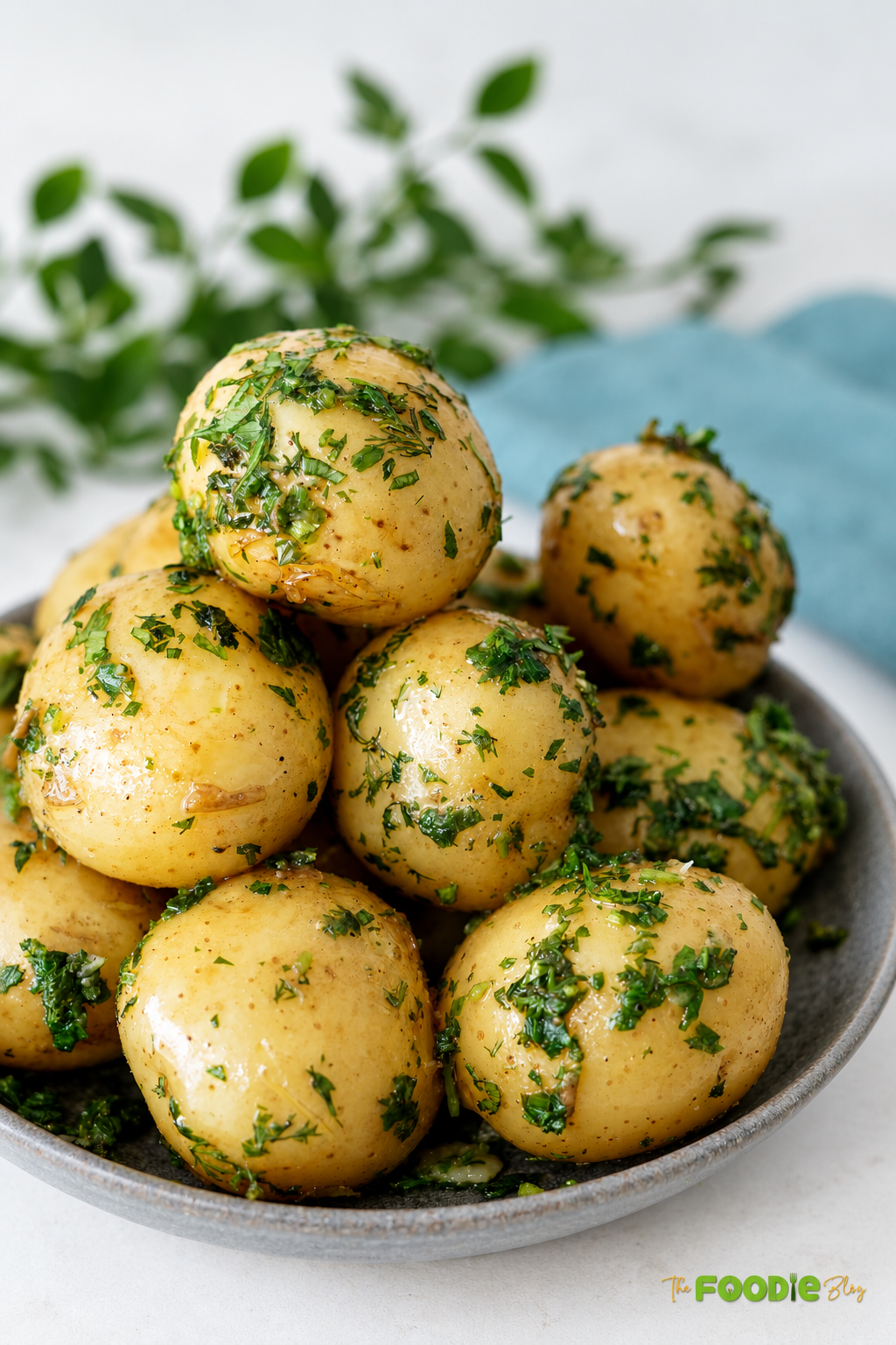 Baby potatoes with melted butter and fresh herbs served in a rustic bowl.