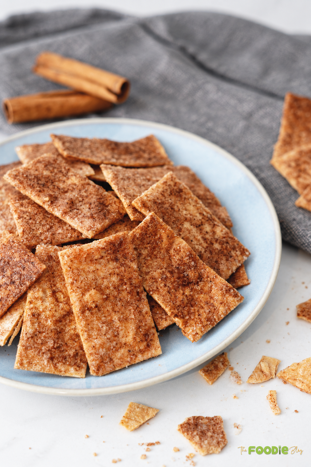 Close-up of baked cinnamon sugar tortilla chips with crisp golden edges and cinnamon coating.