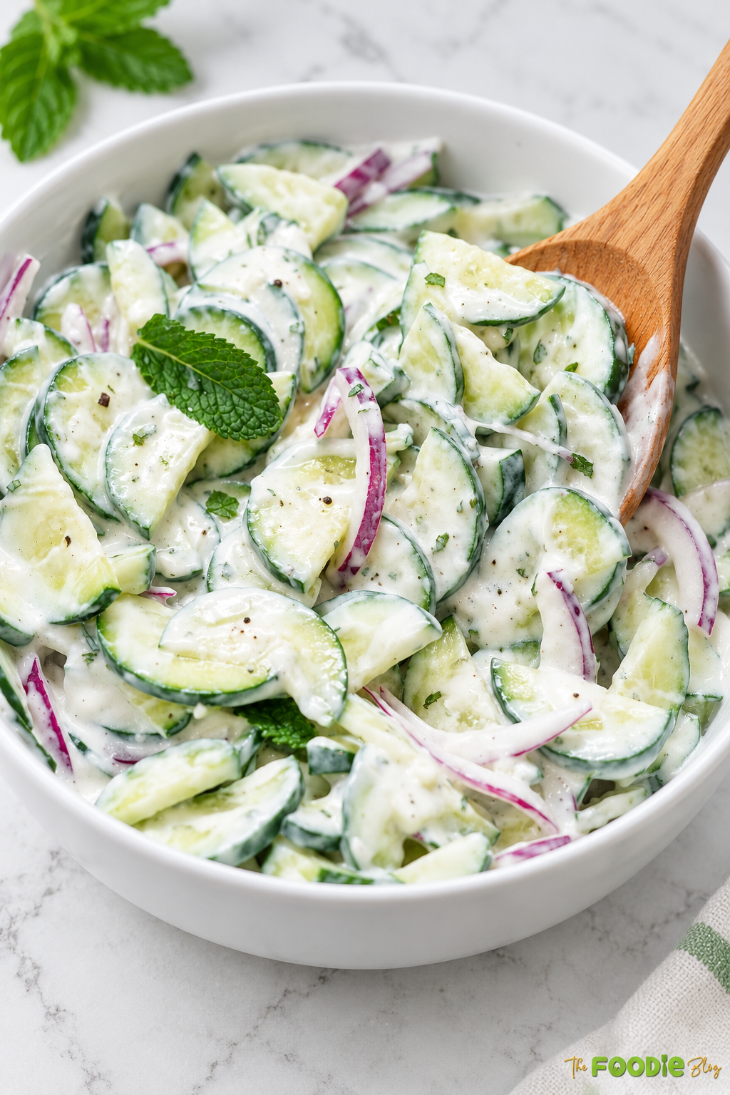 Finished cucumber salad with Greek yogurt dressing, red onion, and fresh mint.