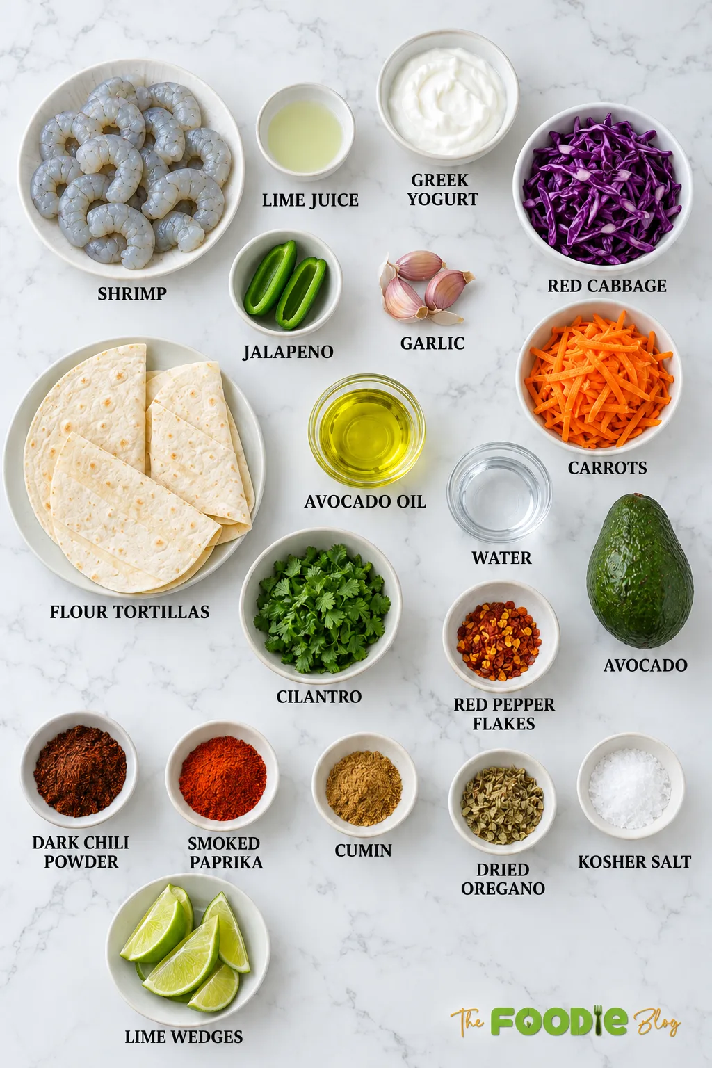 Ingredients for Mexican shrimp tacos including shrimp, tortillas, avocado, Greek yogurt, cabbage, carrots, cilantro, jalapeño, lime, garlic, and spices.