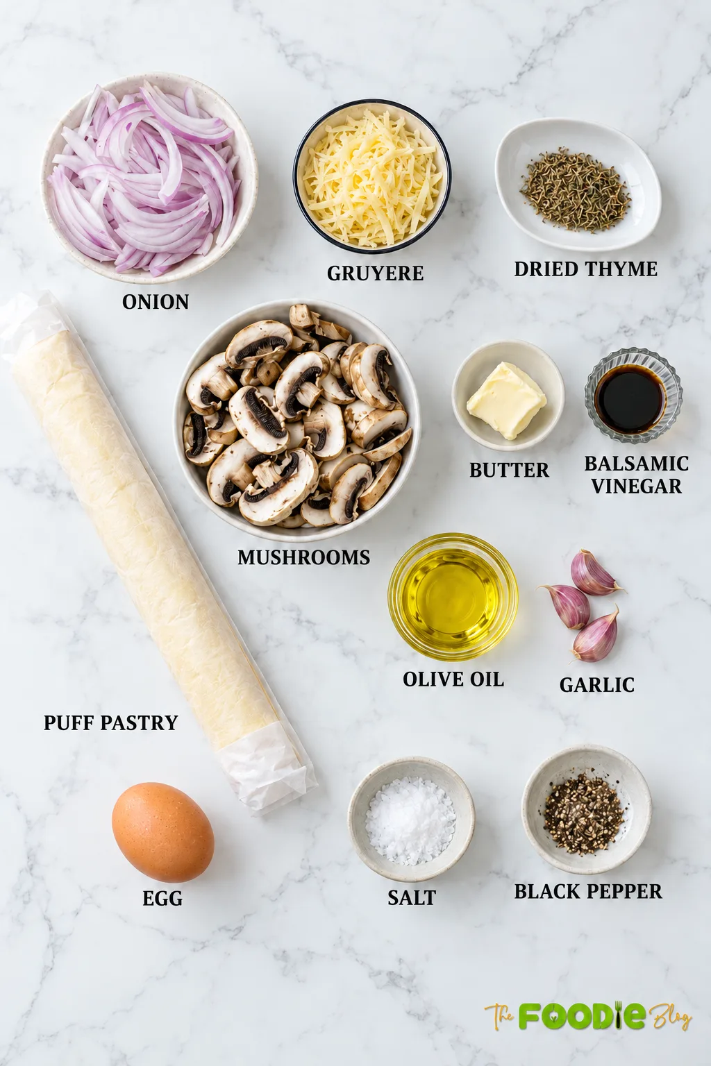Ingredients for mushroom tart including puff pastry, mushrooms, onion, Gruyere, butter, garlic, thyme, balsamic vinegar, olive oil, egg, salt, and pepper.