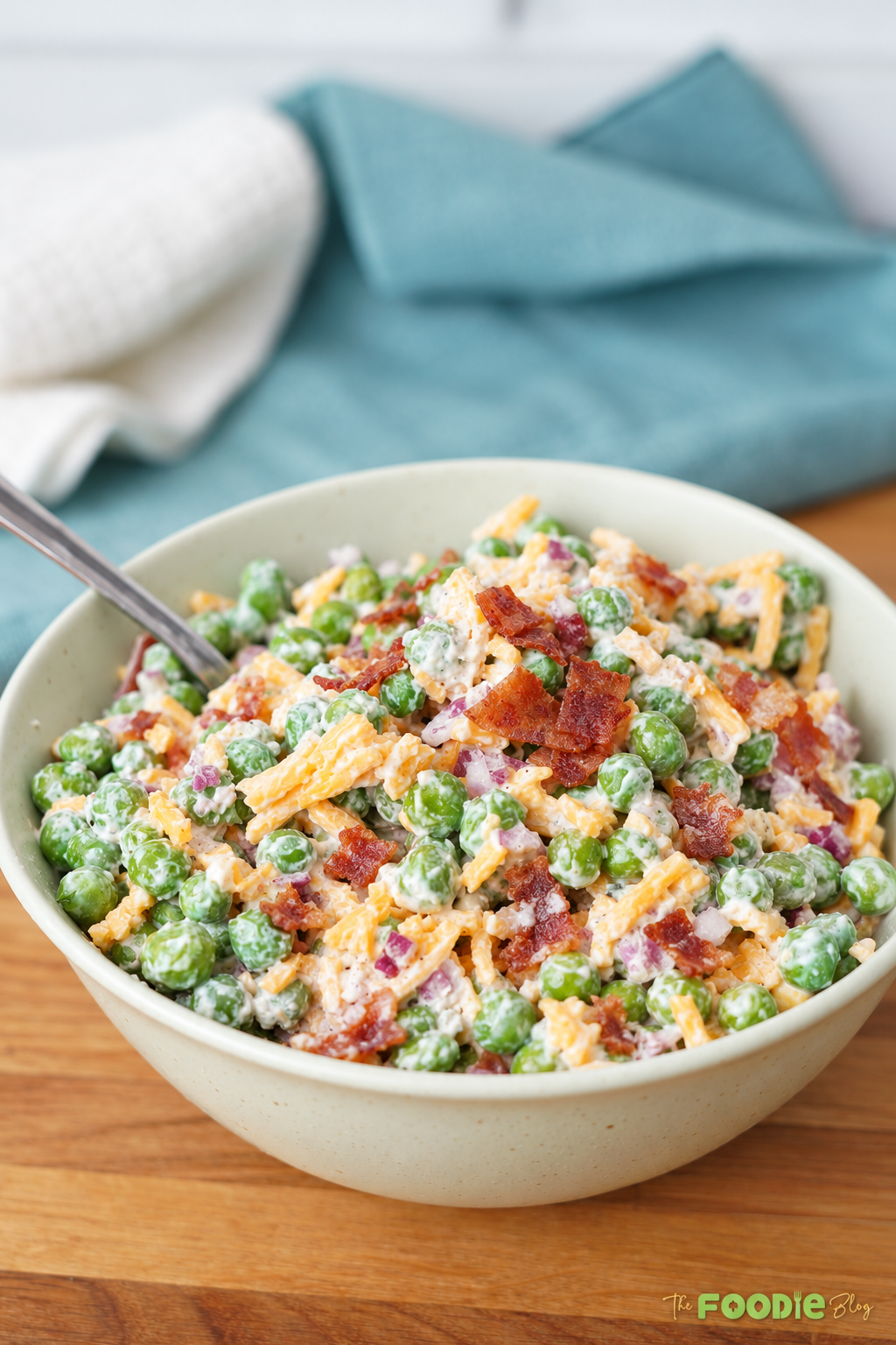 Classic creamy pea salad topped with crispy bacon and shredded cheddar cheese.