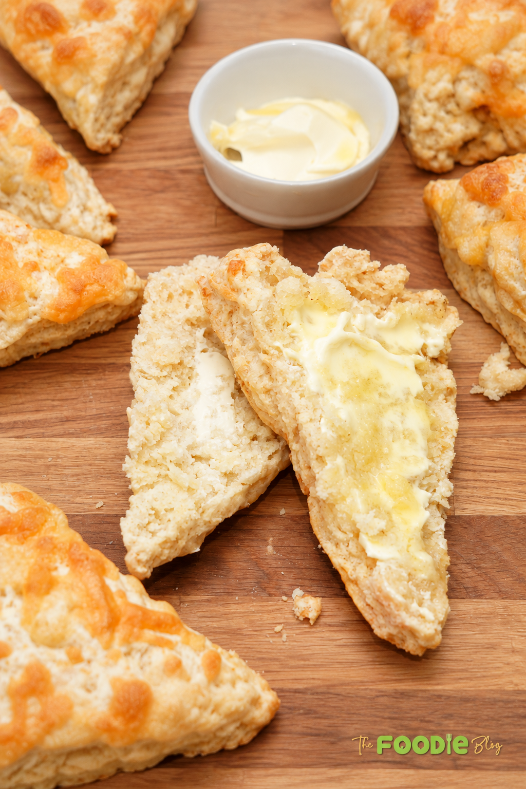 Warm cheddar scone split open and spread with butter.