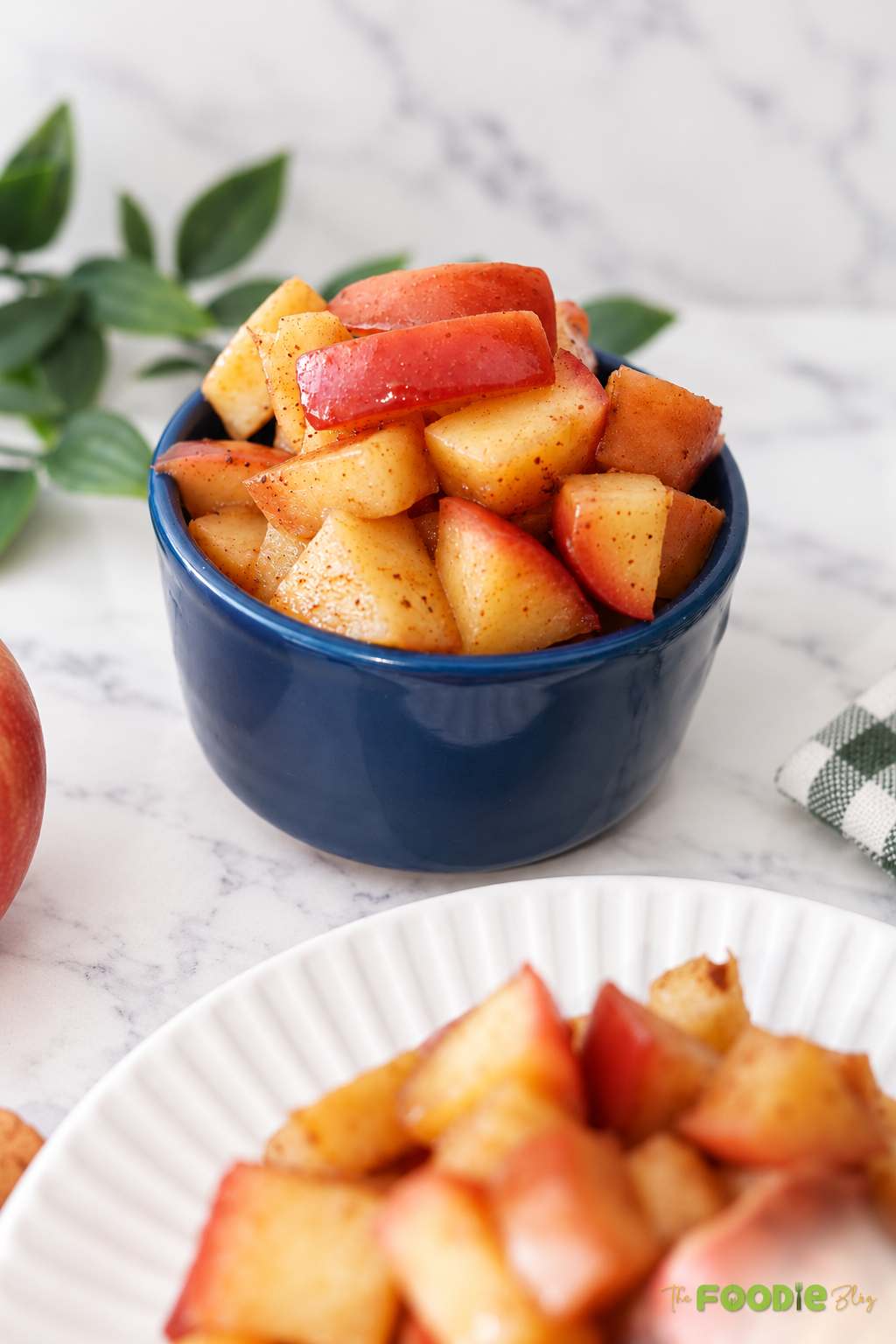 Cinnamon apples with maple syrup served in a blue bowl