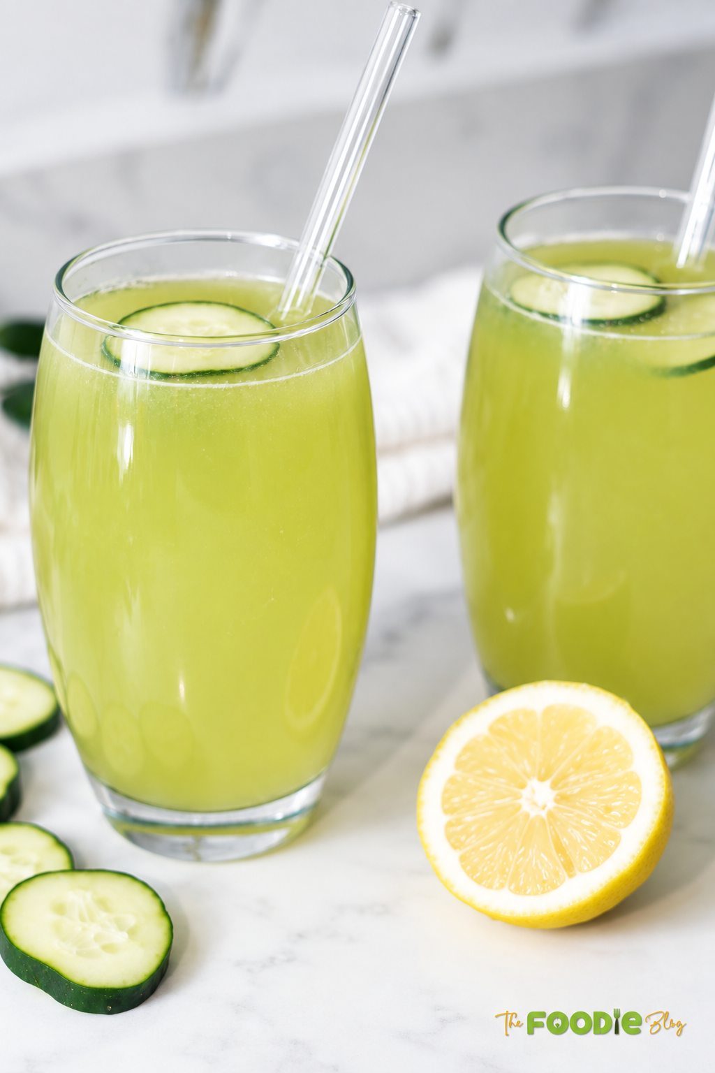 Two chilled glasses of cucumber lemonade garnished with fresh cucumber slices.
