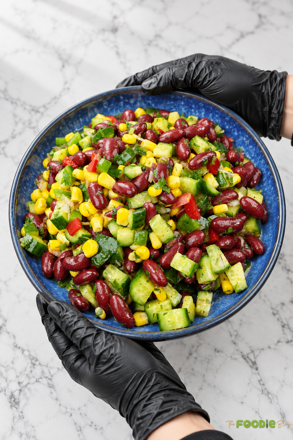 Finished red bean salad with kidney beans, corn, cucumber, peppers, onion, and parsley in a blue serving bowl.