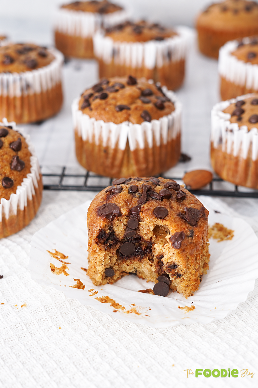 Banana protein muffin cut open to show a moist crumb and melted chocolate chips inside.